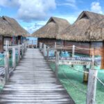 Überwasserbungalows auf Bora Bora mit Holzstegen über türkisblauer Lagune